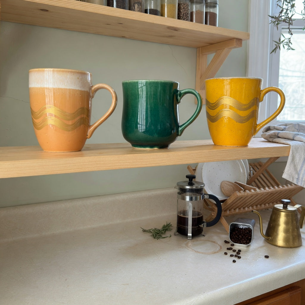 ceramic glazed coffee mugs everyday mug rotation product shortlist guide showing gradient, golden wave, and emerald finishes on an open kitchen shelf
