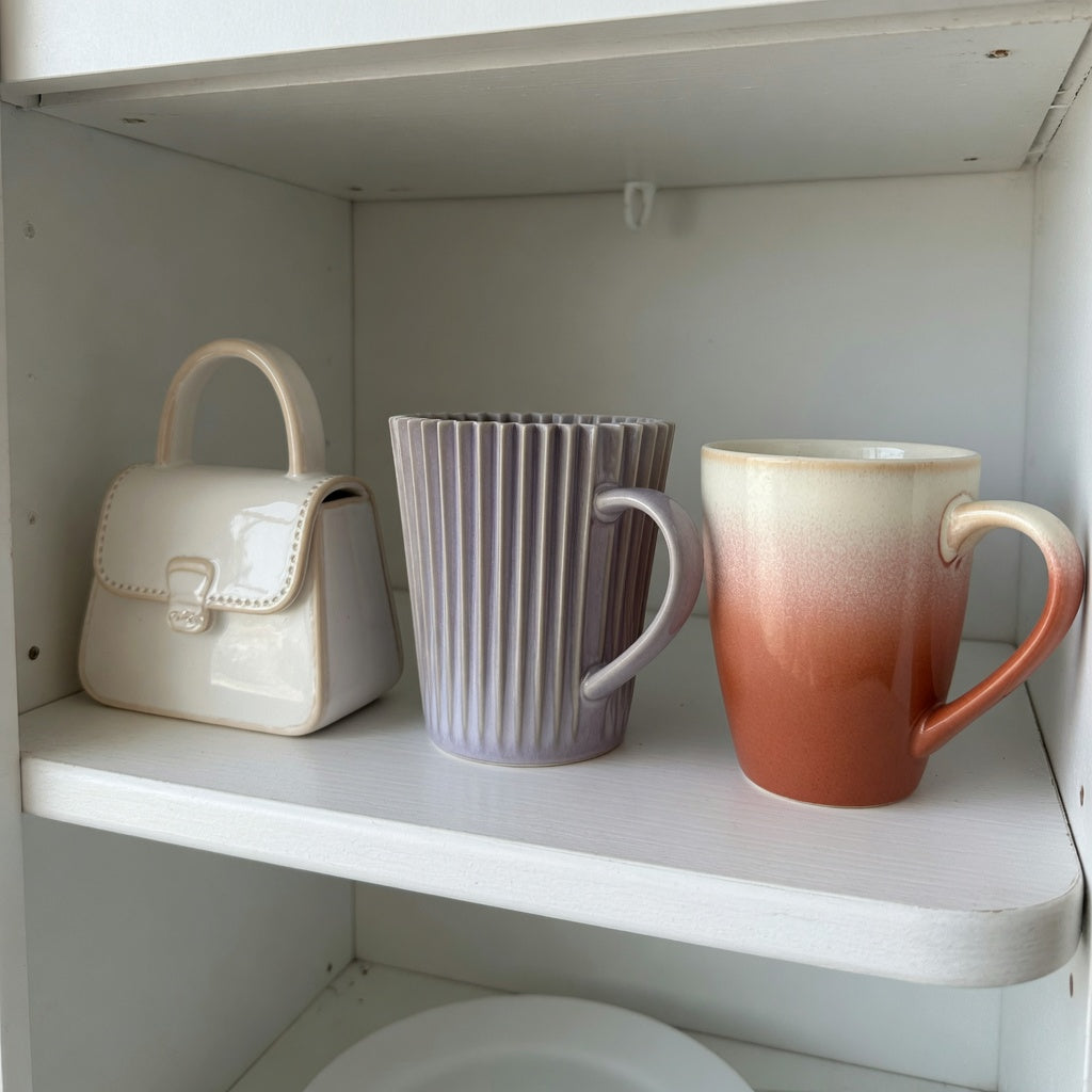 Cute ceramic coffee mugs storage fit guide comparing handbag, pleated, and gradient mug shapes on a cabinet shelf