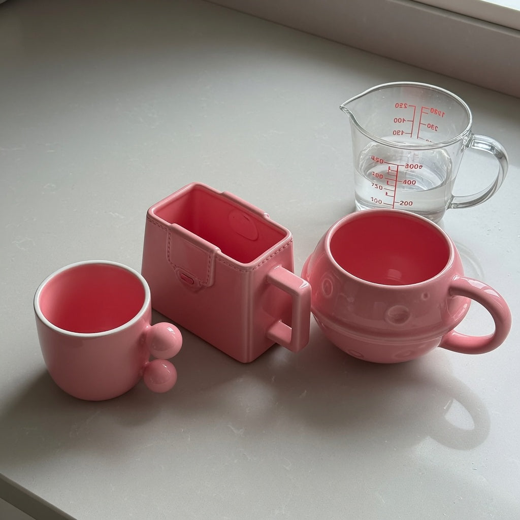 Pink ceramic coffee mug capacity guide showing 250 ml Ball Handle, 310 ml Handbag, and 380 ml Planet mugs side by side