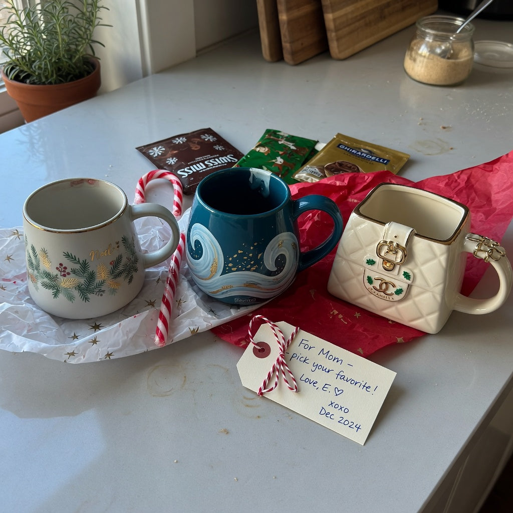 Unique Christmas mug gifts compared on a kitchen counter with cocoa packets and gift wrapping