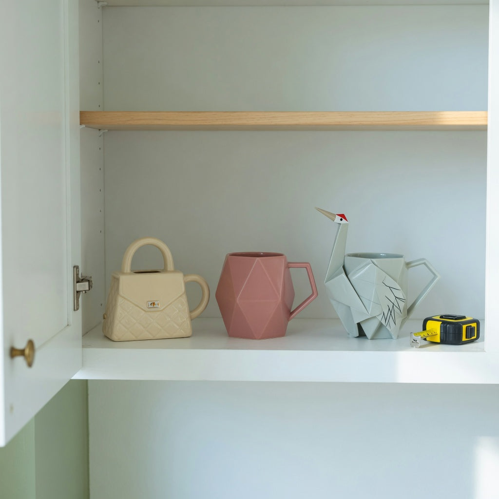 Unique coffee mugs for gifts storage fit guide showing Handbag, Rhombus, and Crane mug shapes measured on a cabinet shelf