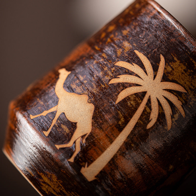 Close view of the camel and palm motif on the brown glazed mug