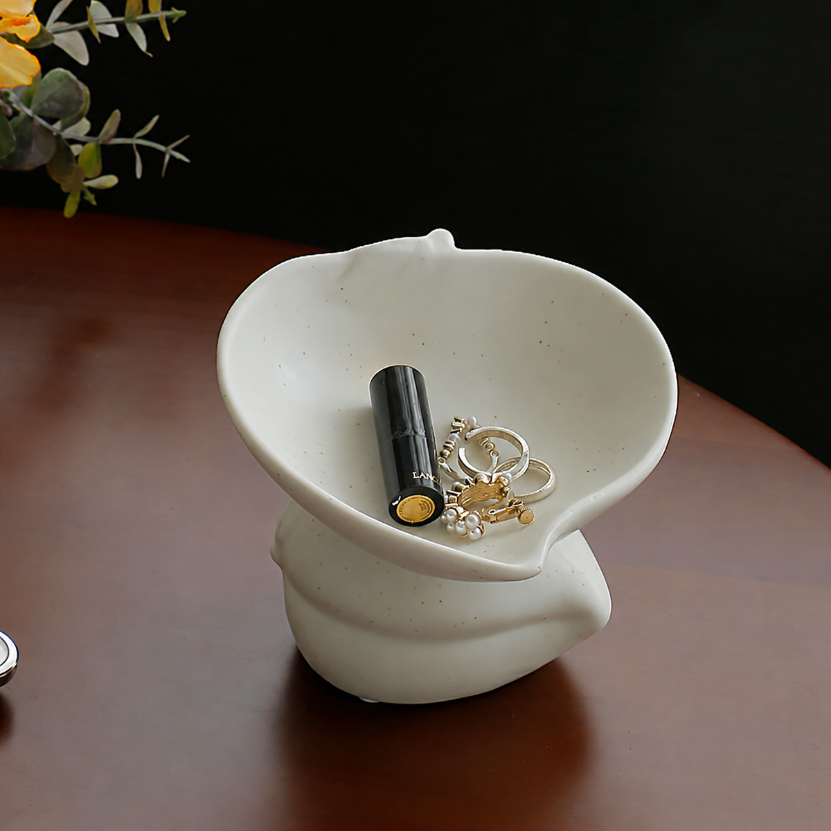 White speckled peach-shaped ceramic trinket dish with a sculptural pedestal
