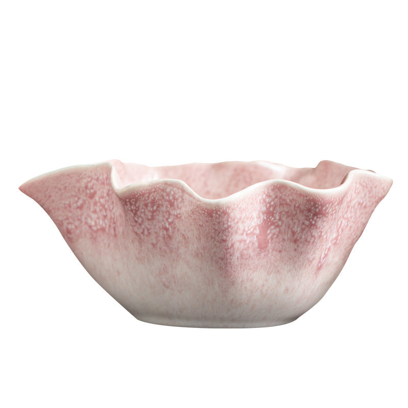 Close view of the pink bowl's wavy petal rim and speckled ceramic glaze