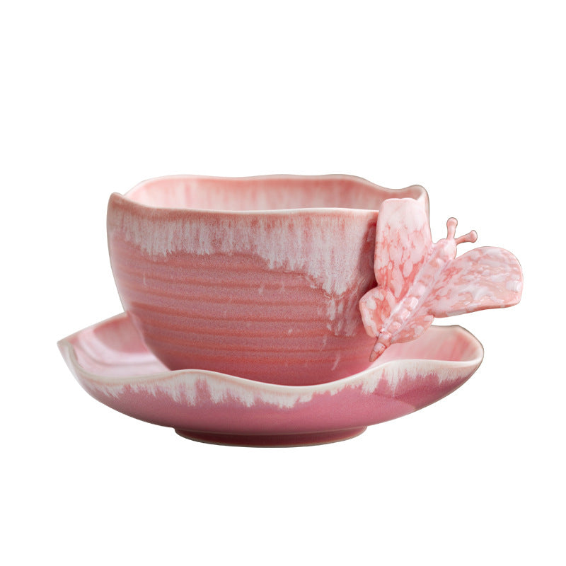 Pink butterfly-handled ceramic coffee cup with matching saucer