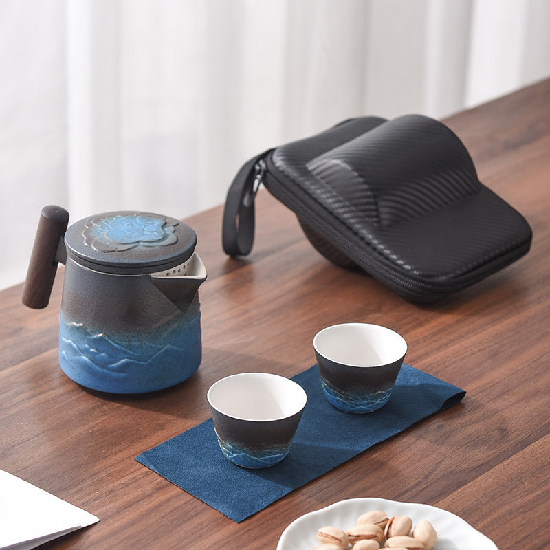 Blue and black ceramic teapot with two cups and carrying case
