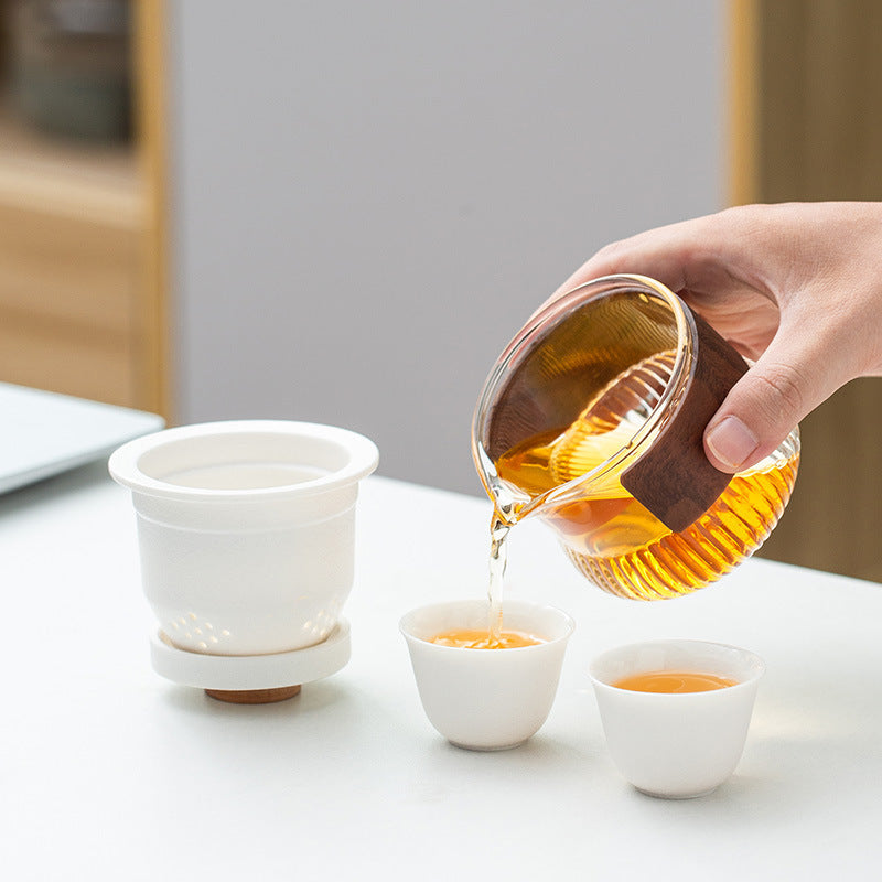 Pouring tea from the glass pitcher with the ceramic infuser resting on the lid