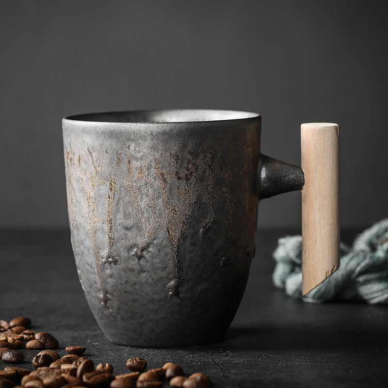 Rounded Cup in dark textured ceramic with a warm metallic glaze and wooden handle