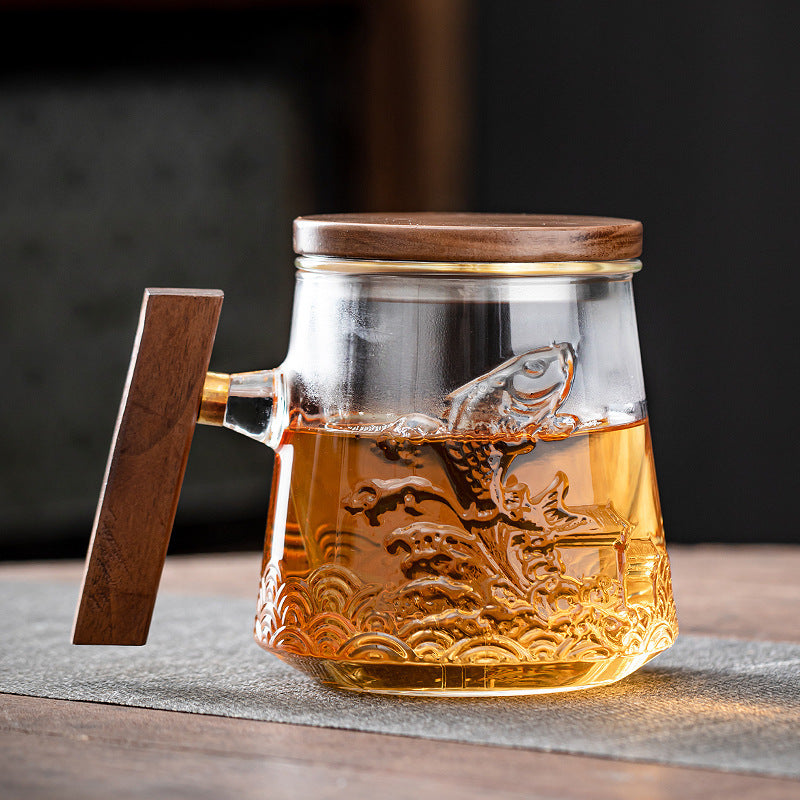 Clear glass tea mug with raised koi decoration and wood handle