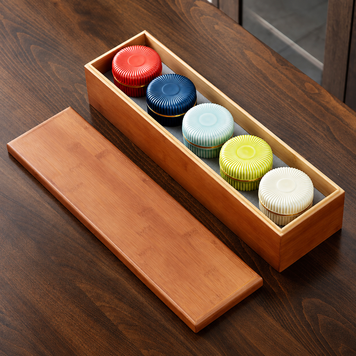 Five large ribbed ceramic tea jars in five colors with a fitted bamboo box and detached lid