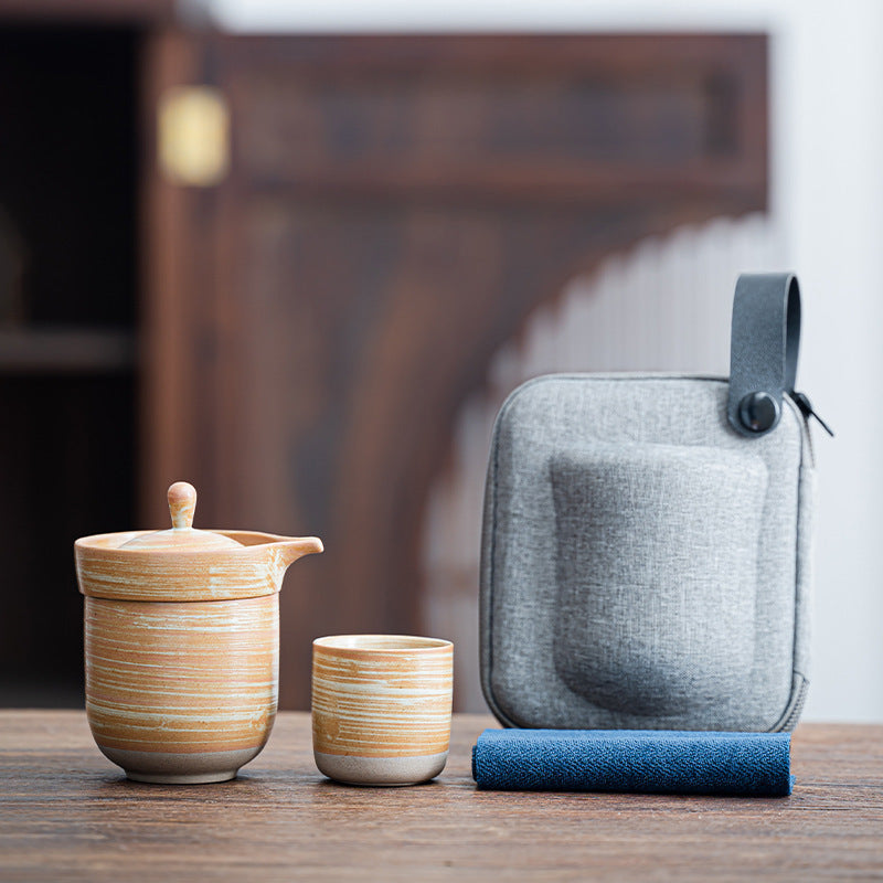 Ochre striped ceramic travel tea set with a nesting cup and gray carry case