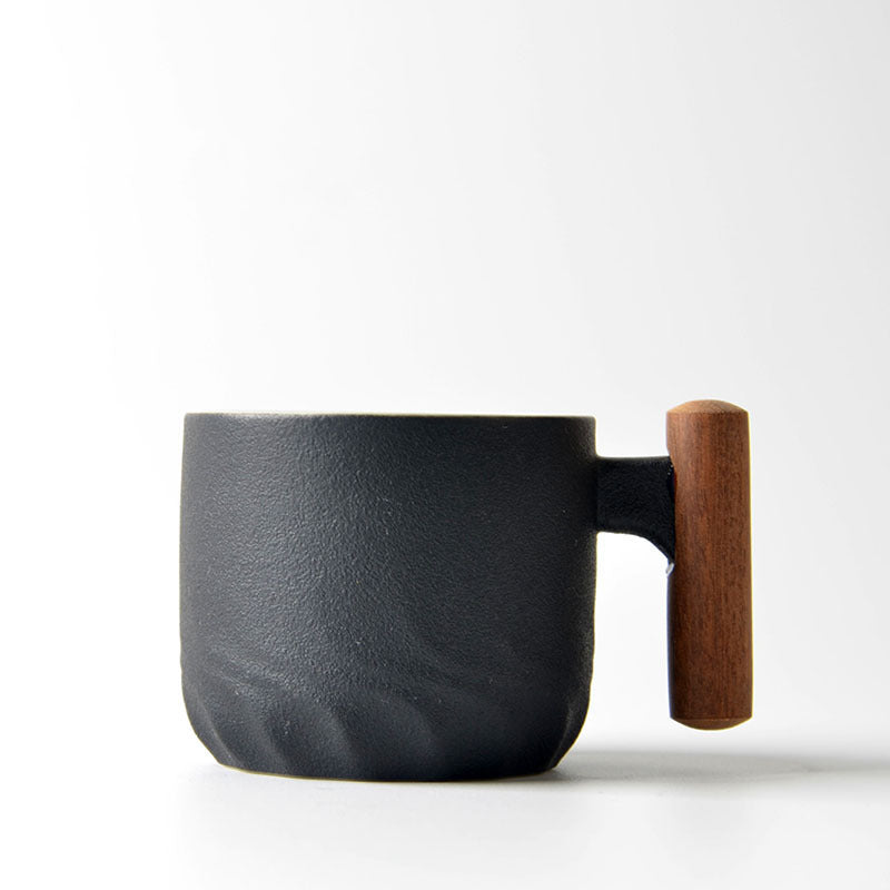 Black ceramic tea cup with a vertical wooden handle