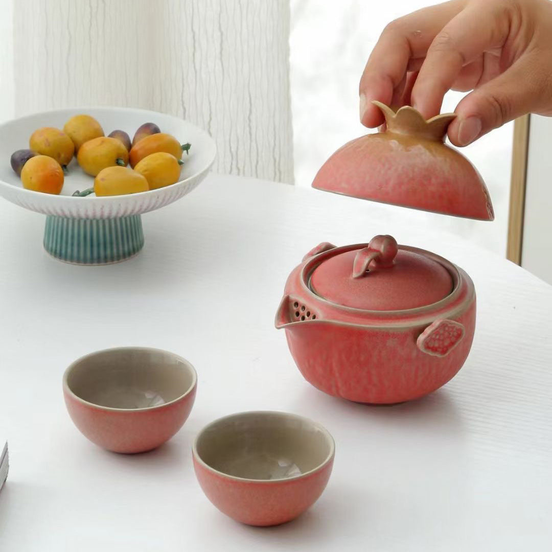 Outer cover lifted above a pomegranate shaped tea brewer