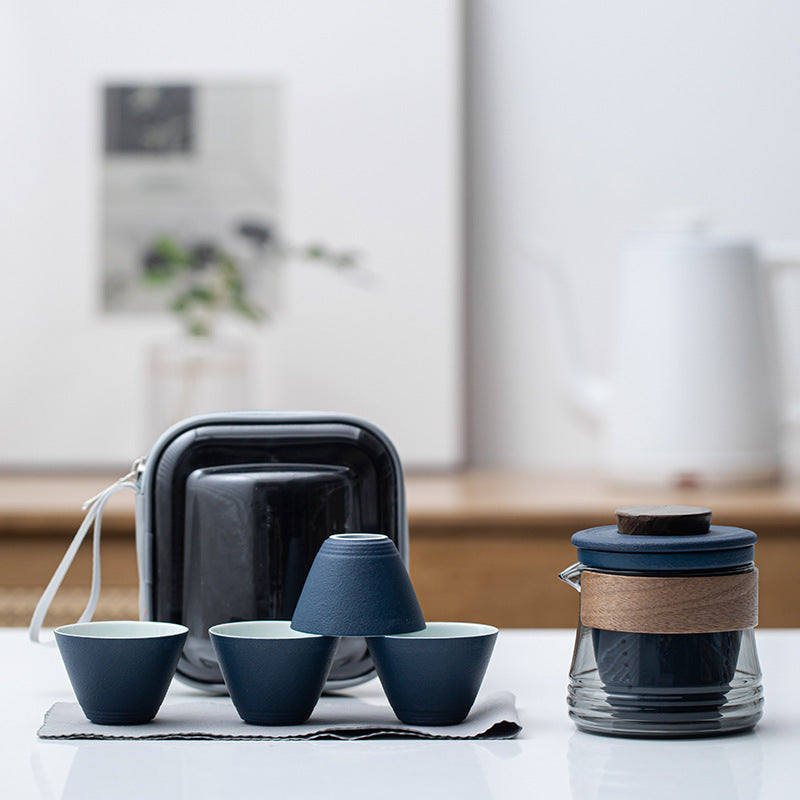 Blue ceramic travel tea set with smoke-gray glass brewer, four cups and zip case