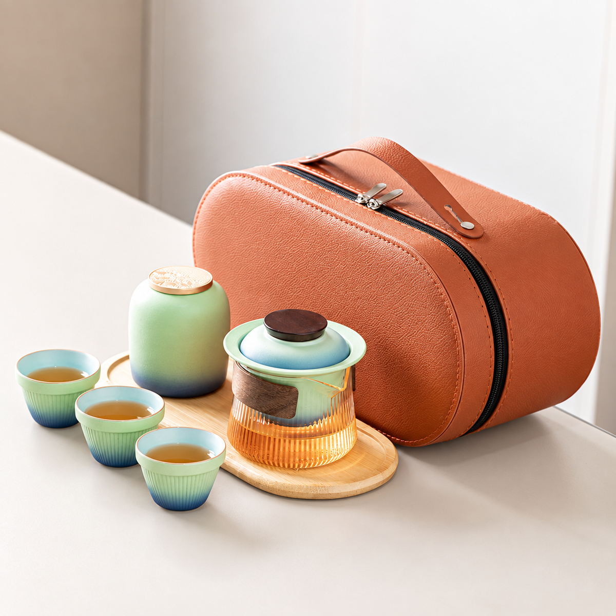 Blue gradient travel tea set with a wood-grip glass brewer, three cups, jar, tray and orange case