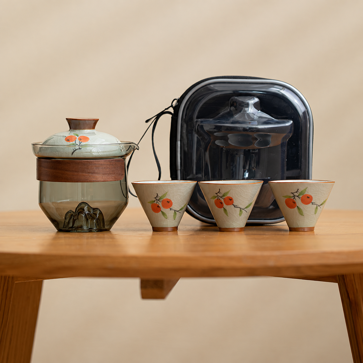 Persimmon / Smoke glass tea brewer with three patterned ceramic cups and a black travel case
