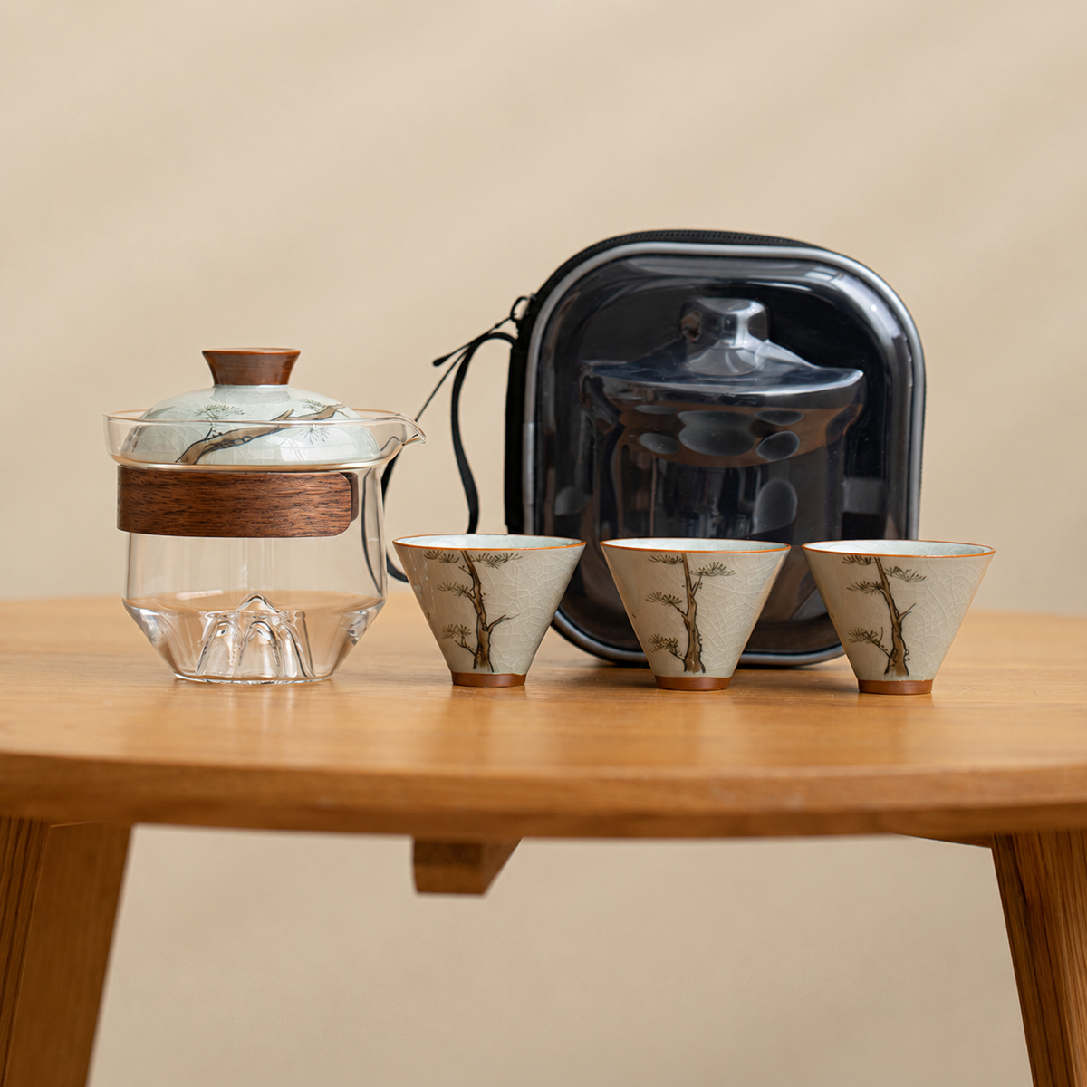 Pine / Clear glass tea brewer with three patterned ceramic cups and a black travel case