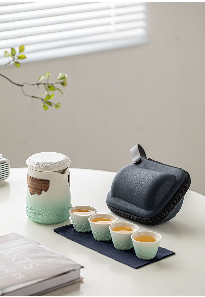 White and mint wave-relief tea brewer with four cups, cloth and navy carrying case
