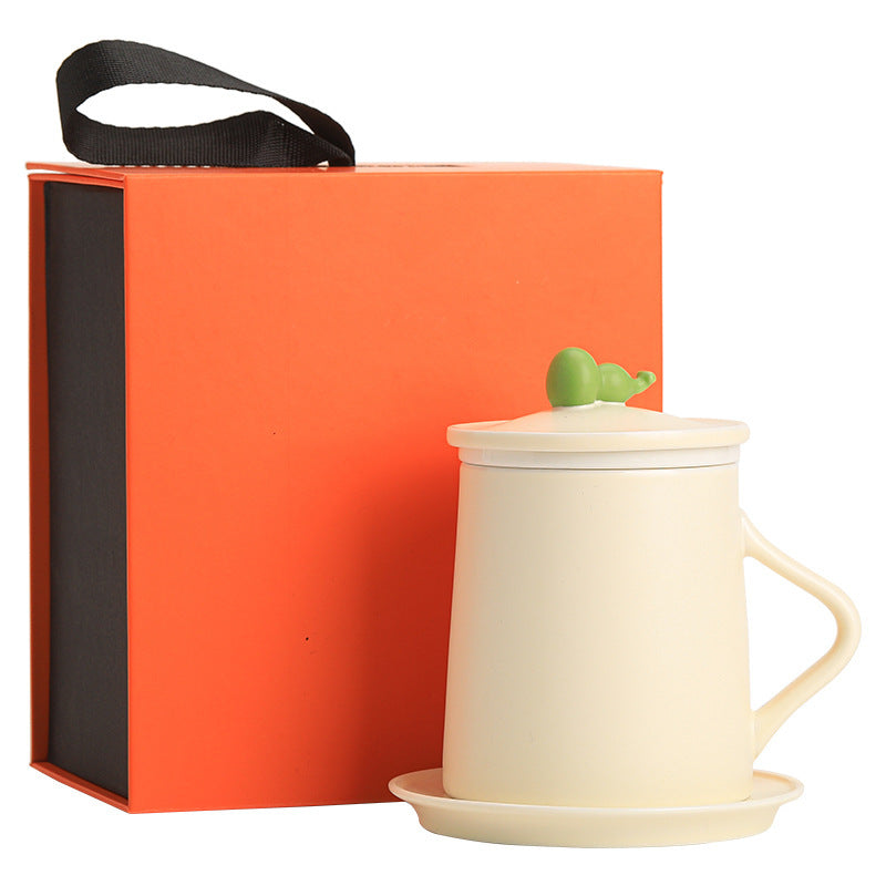 Cream ceramic-handle mug without an infuser, shown with its saucer and actual orange gift box