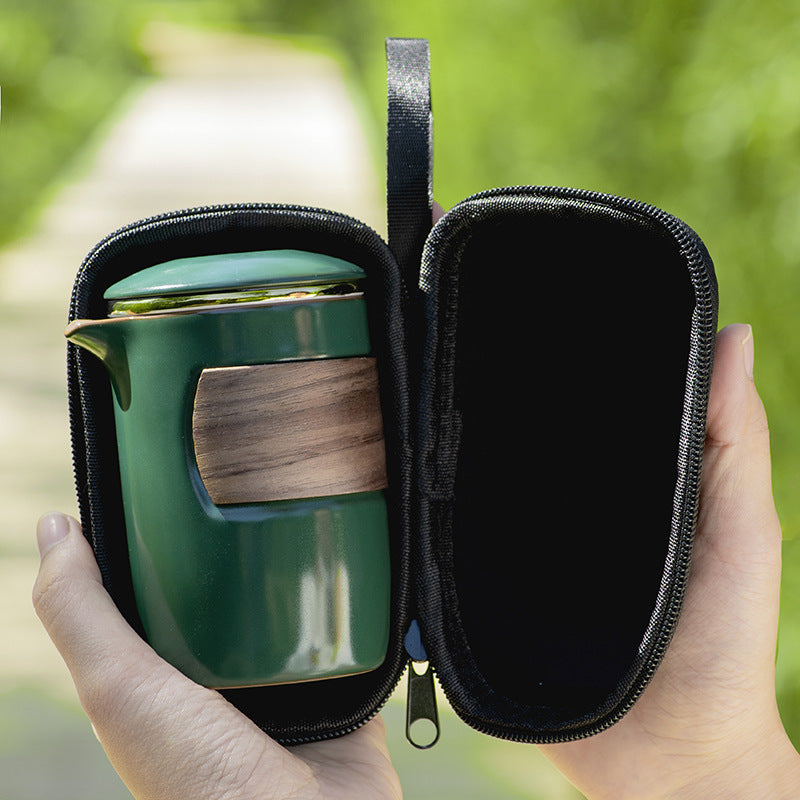 Green ceramic tea brewer shown inside its open zippered carrying case