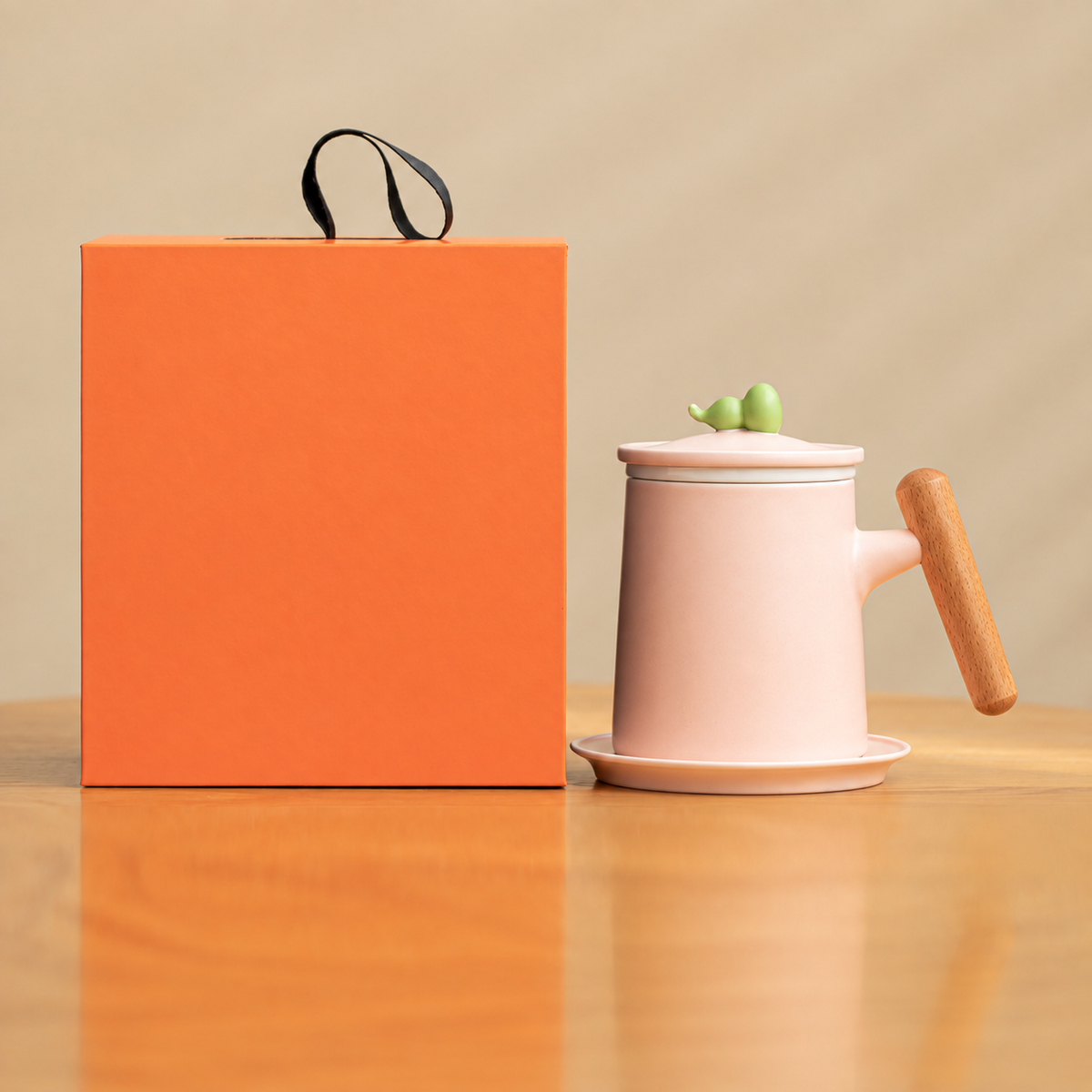 Pink gourd-knob ceramic infuser mug with wood grip, saucer and orange gift box