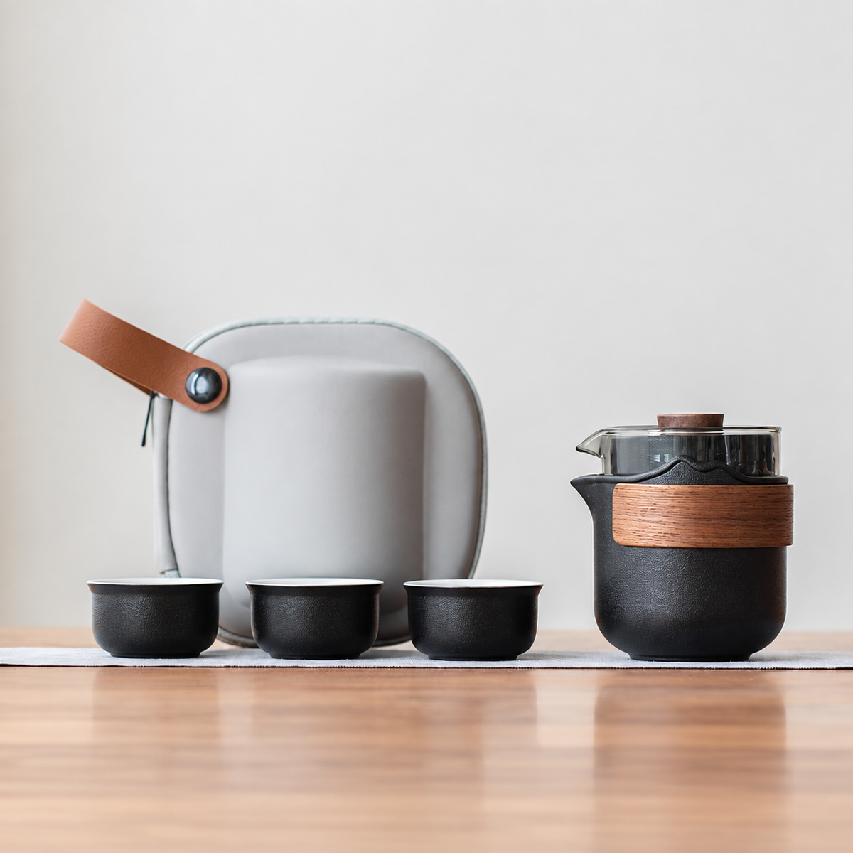 Black nested glass and ceramic travel tea set, bamboo wrap configuration, with three cups and gray case