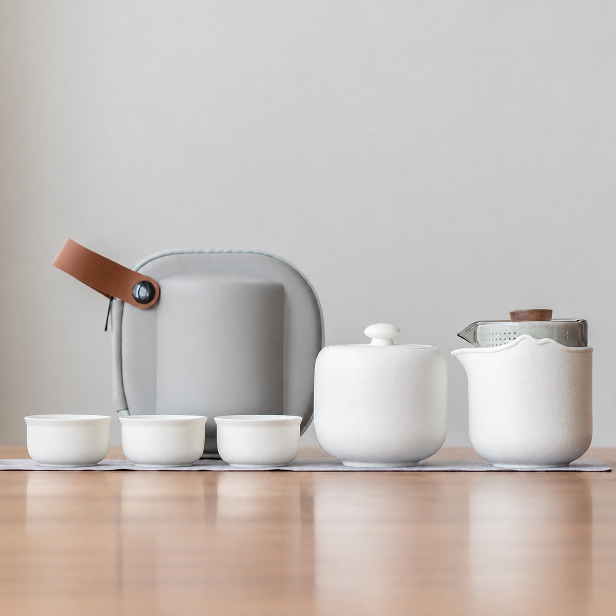 White nested glass and ceramic travel tea set, tea jar configuration, with three cups and gray case