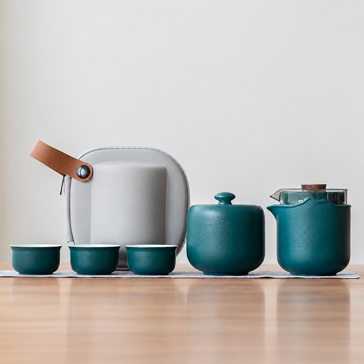 Green nested glass and ceramic travel tea set, tea jar configuration, with three cups and gray case