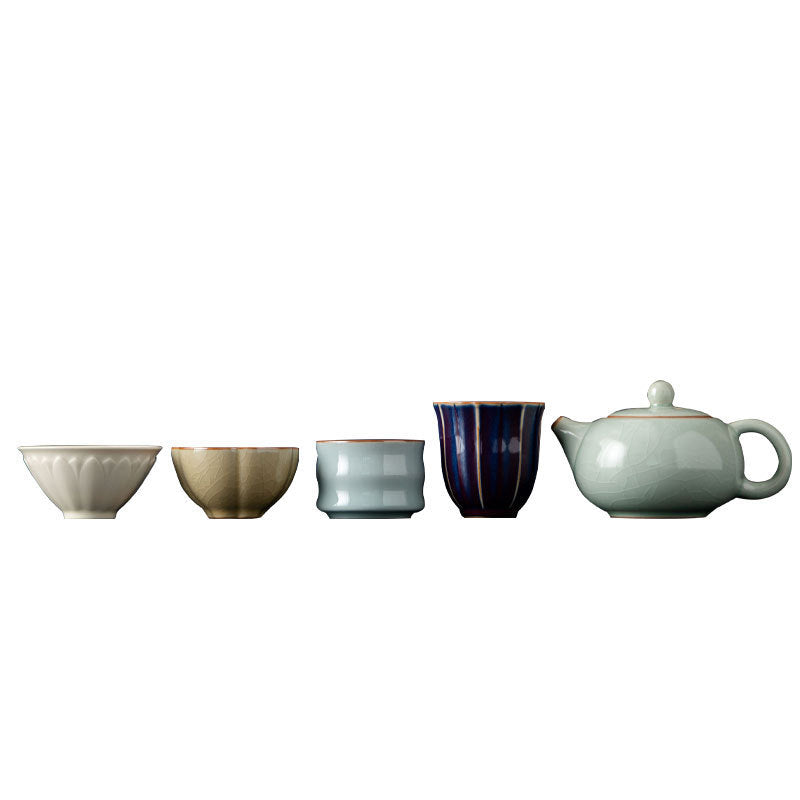 Round celadon teapot with four ceramic tea cups in contrasting glazes