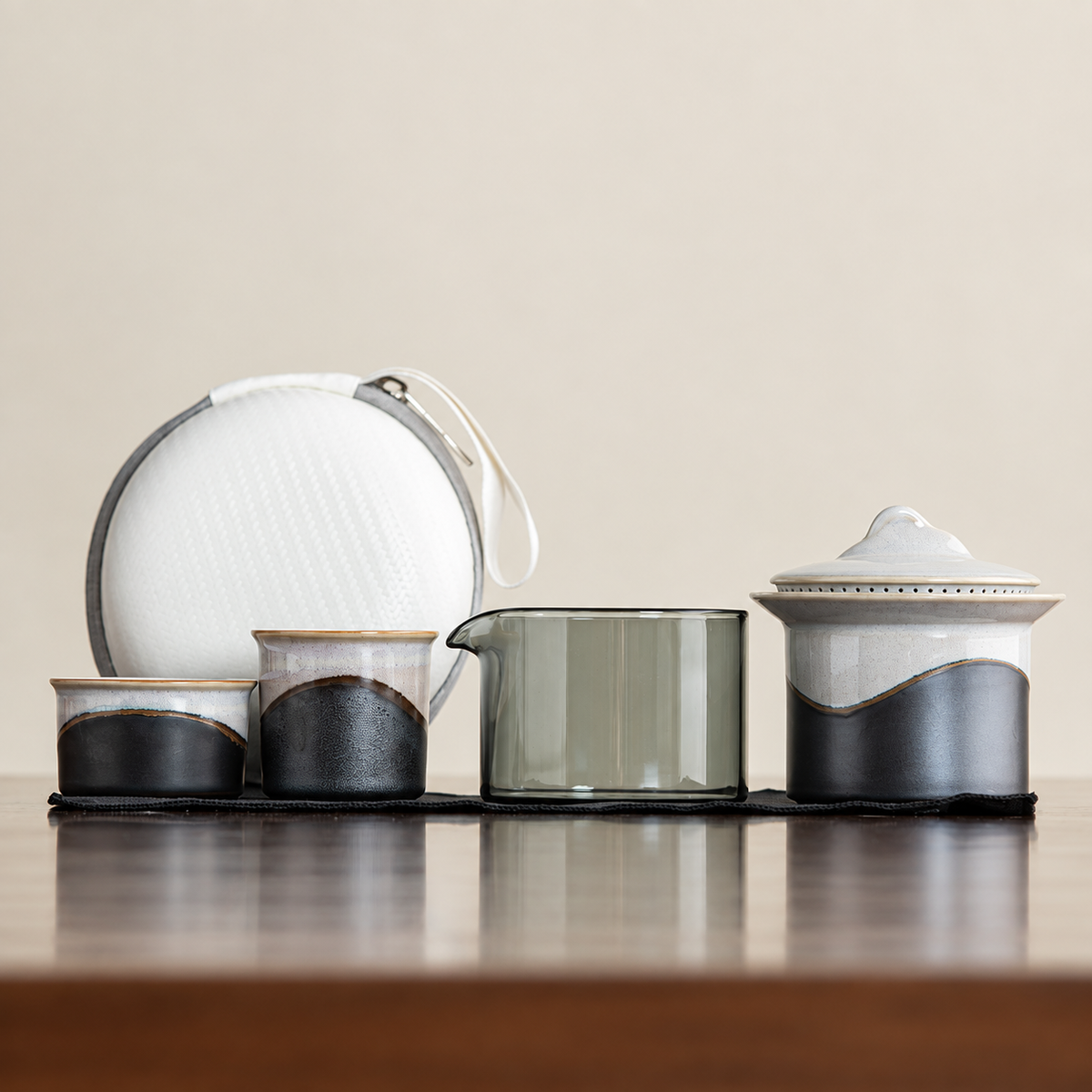 Black landscape-glaze travel tea set with two cups, glass pitcher, lidded brewer and white case