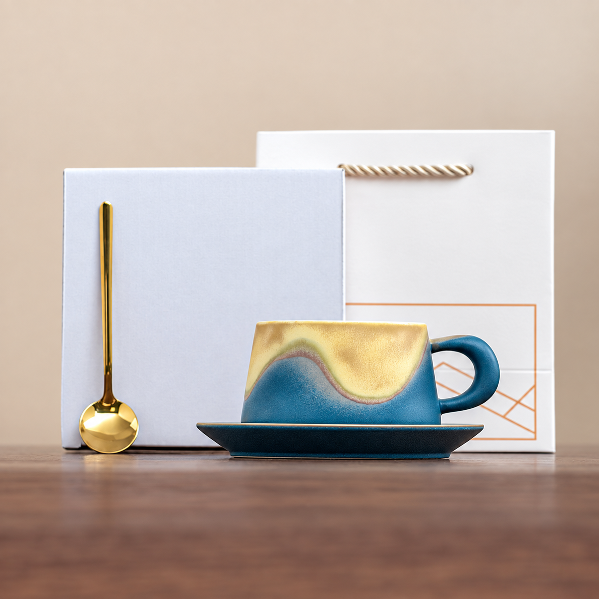 Blue wave-glaze cup and saucer with gold-tone spoon, plain box and geometric gift bag
