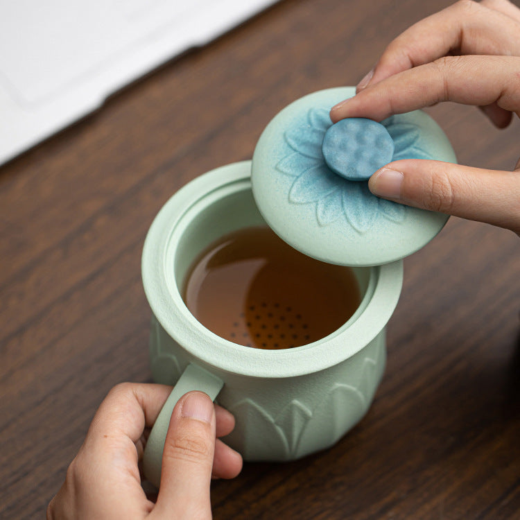 Lotus mug lid lifted to show the ceramic tea infuser