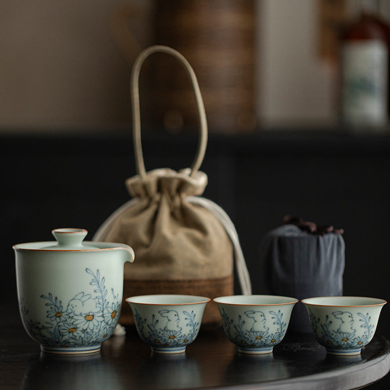 Rabbit and daisy painted celadon brewer with three cups, tan carrying bag and dark inner pouch