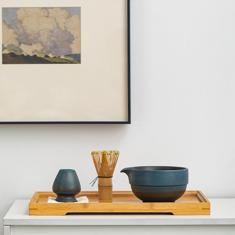 Blue and black matcha bowl, whisk and holder on a display tray; tray and cloth are styling props and are not included