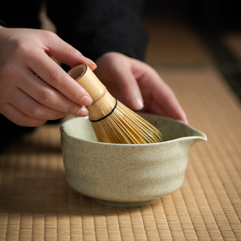 Bamboo matcha whisk in use in a tea bowl