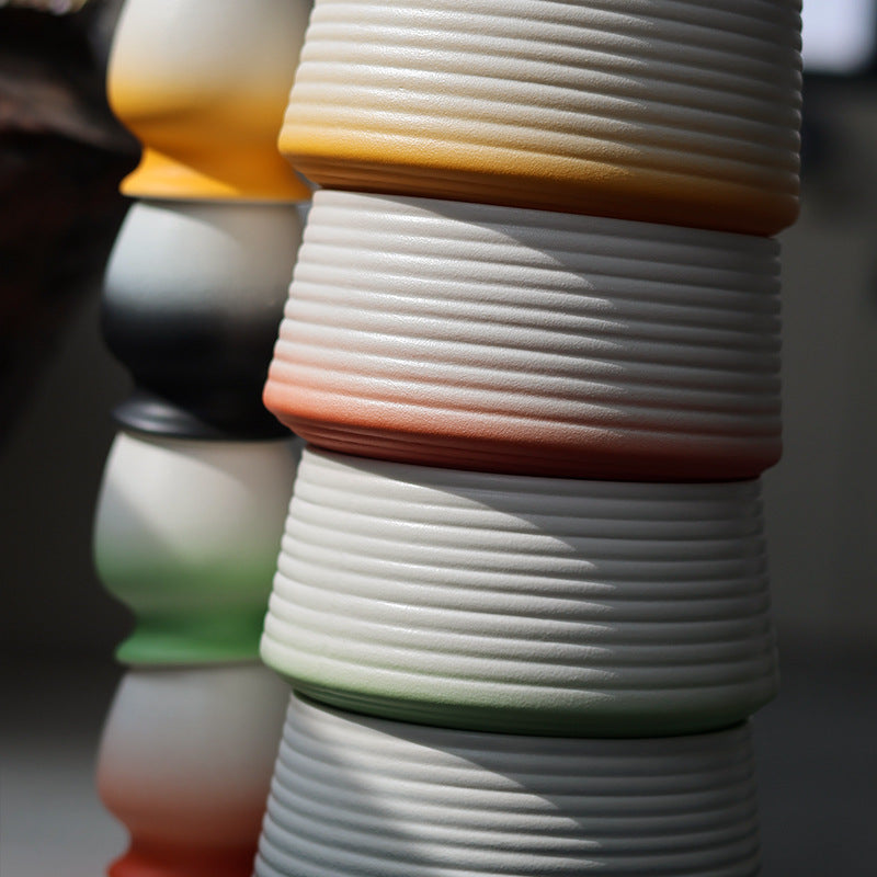 Close-up of the ribbed ceramic bowls showing the orange, soft red, green and black gradient finishes