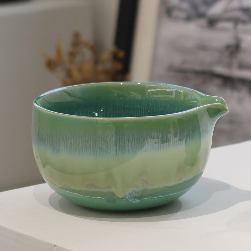 Close-up of the forest green bowl showing its pouring spout, interior and flowing glaze