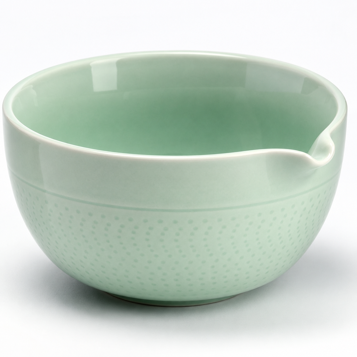 Close view of the celadon bowl showing its formed pouring lip, smooth rim and chattered surface texture