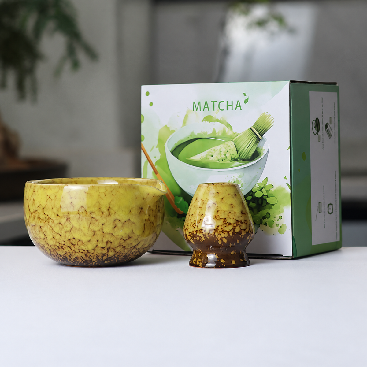 Yellow mottled reactive-glaze matcha bowl and whisk holder beside the actual English MATCHA box