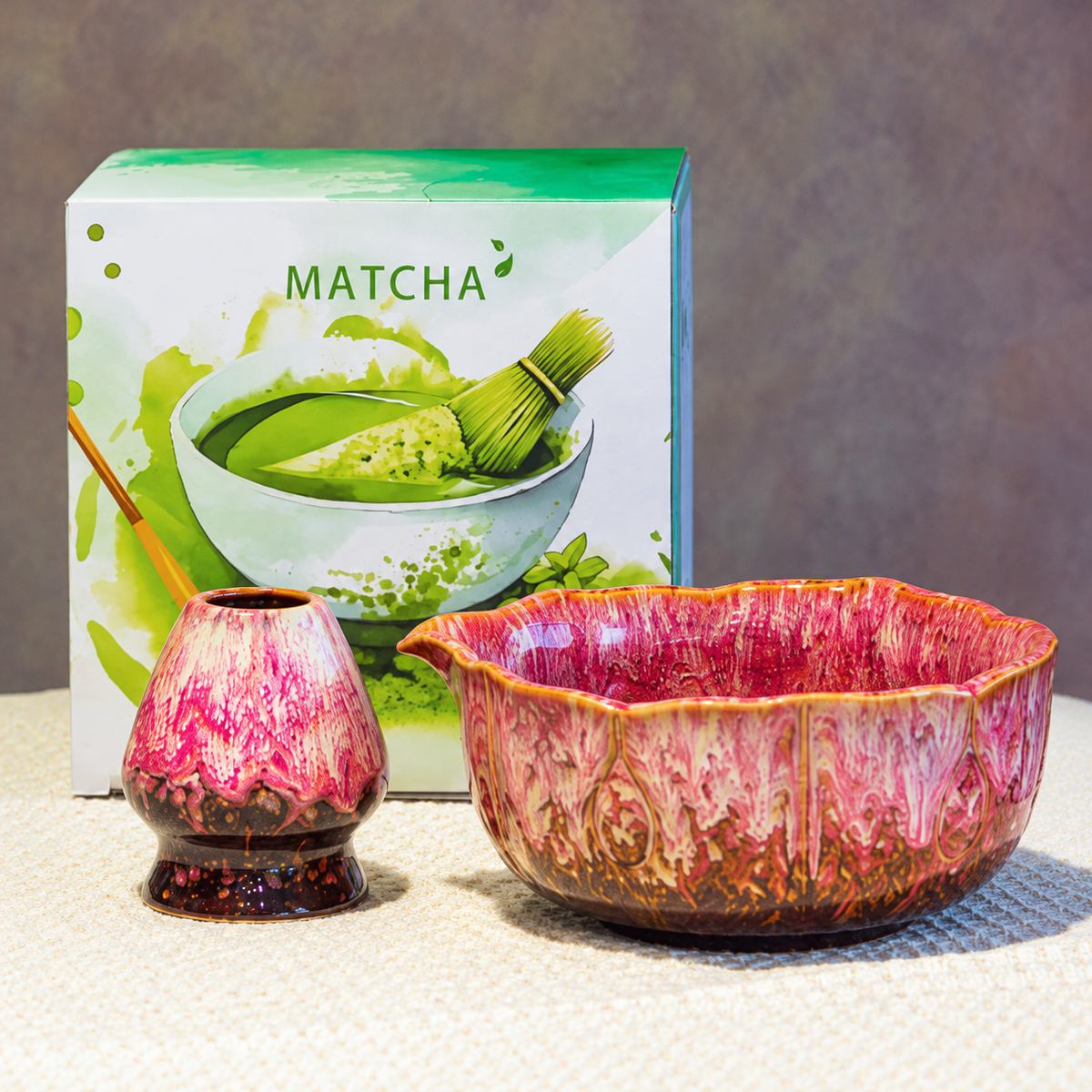 Red reactive-glaze lotus-rim matcha bowl and matching ceramic whisk holder with the included MATCHA presentation carton.