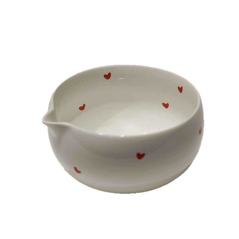 Close-up of the red-heart bowl showing the interior, rounded rim and pouring spout