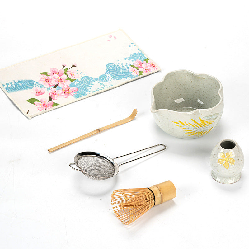 Overhead view of yellow fern bowl showing its petal rim, speckled interior and floral holder beside preparation props