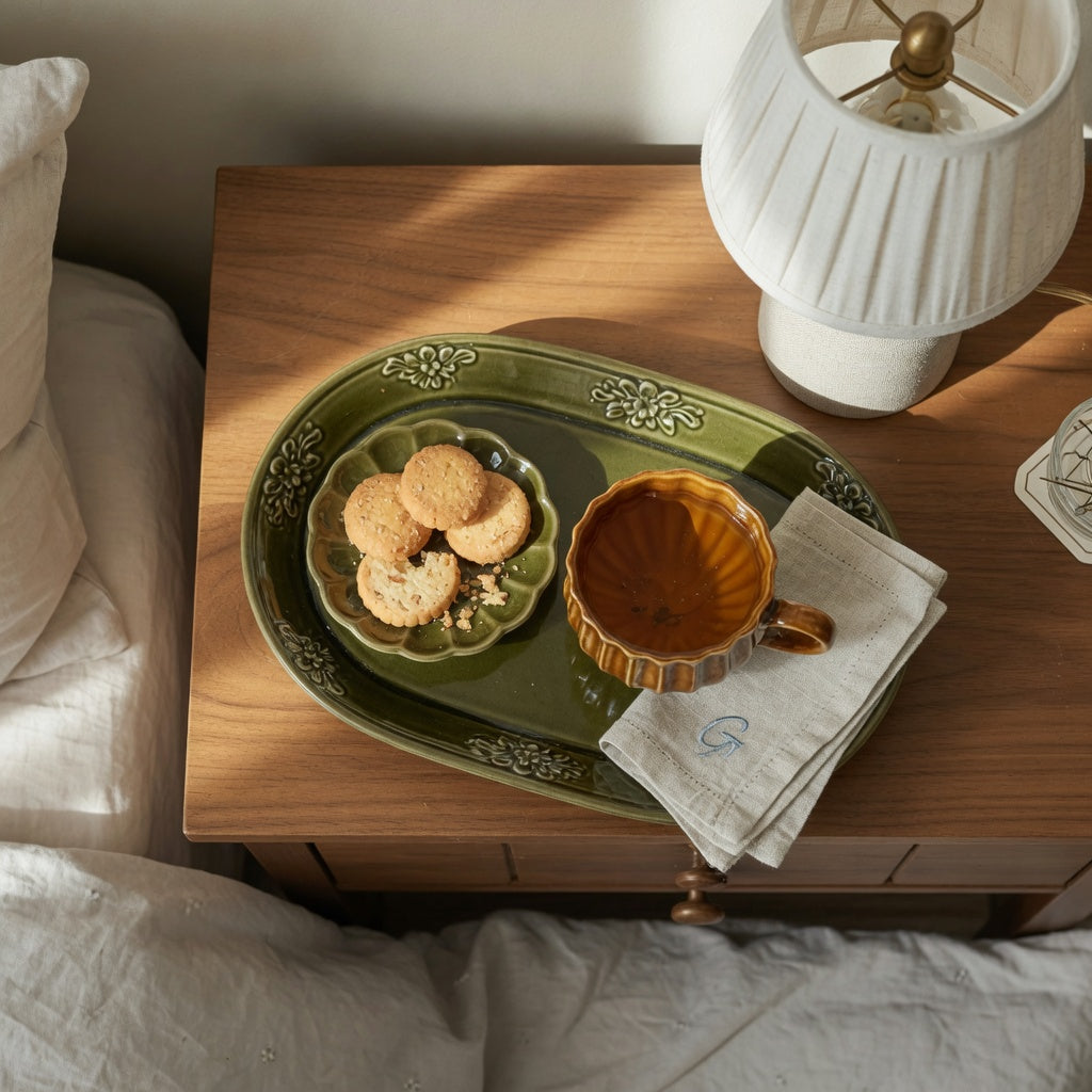 Ceramic cup tea tray guest room setup on a nightstand with a pleated ceramic cup of tea beside a lamp
