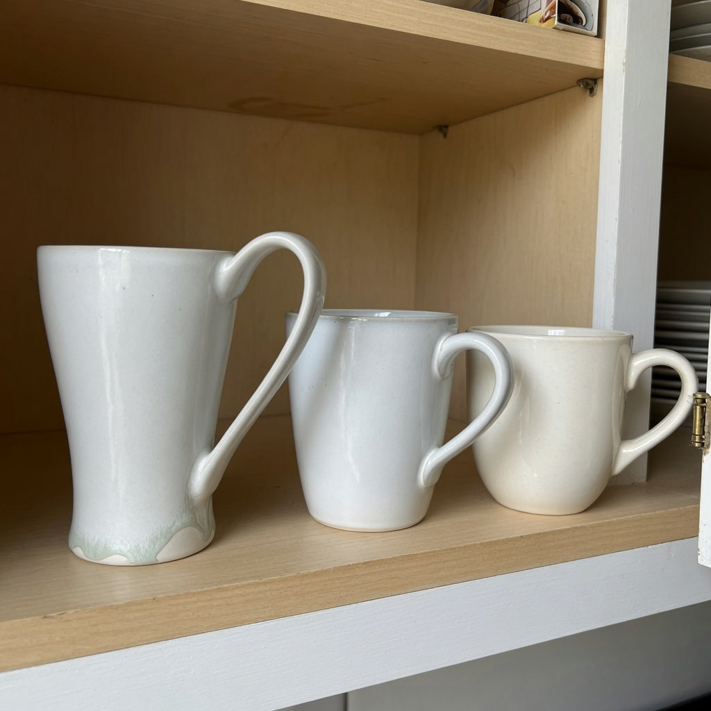 Ceramic tea mug storage fit guide showing Flow, Morning Night, and Round ceramic mug shapes aligned on a cabinet shelf for handle-clearance comparison
