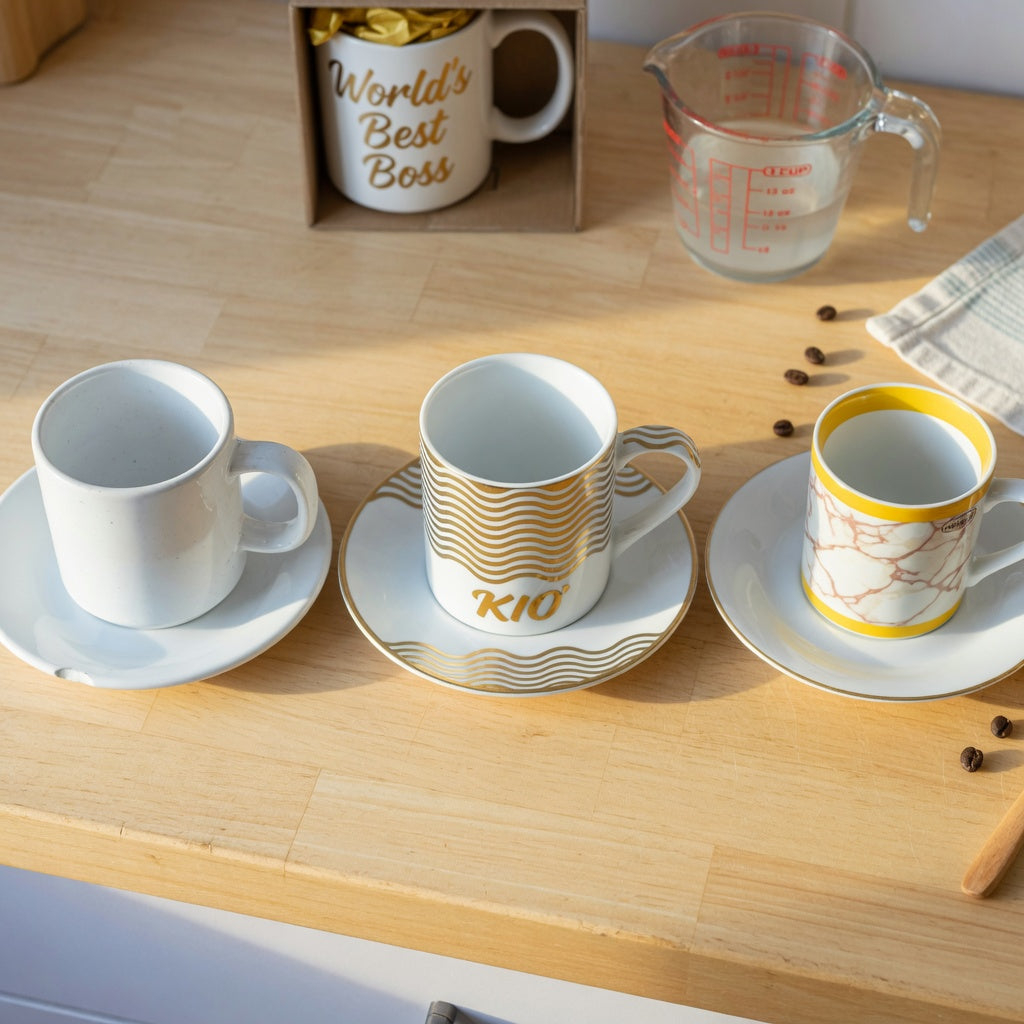 Kio Golden Waves mug vs alternatives — gold wave mug beside a plain white ceramic mug and a generic gold-rim lookalike on a kitchen counter