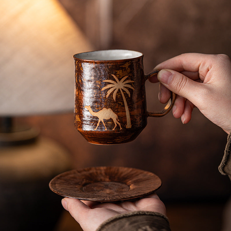 Camel mug and matching ceramic saucer held in two hands