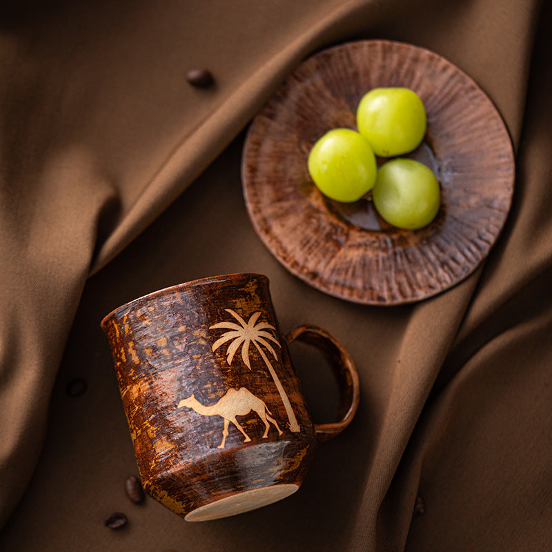 Camel mug and matching saucer arranged on brown fabric