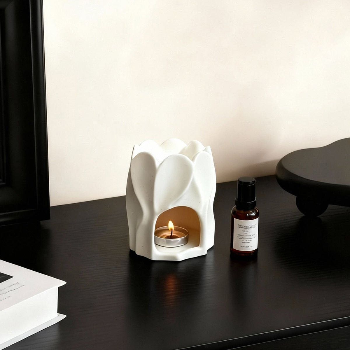 White ceramic petal aroma burner styled on a dark tabletop