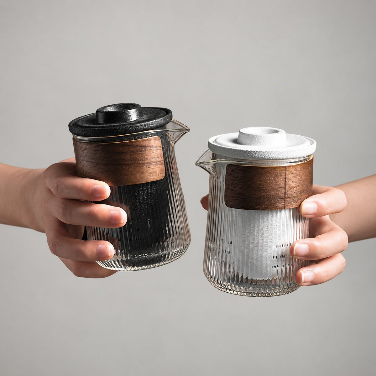 Black and white ceramic tea infusers inside ribbed glass brewers