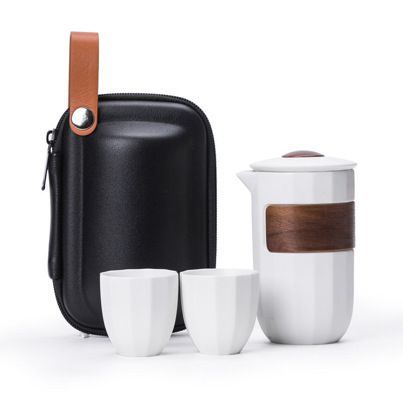 White ceramic travel tea set with two cups, a banded pitcher and a black carry case